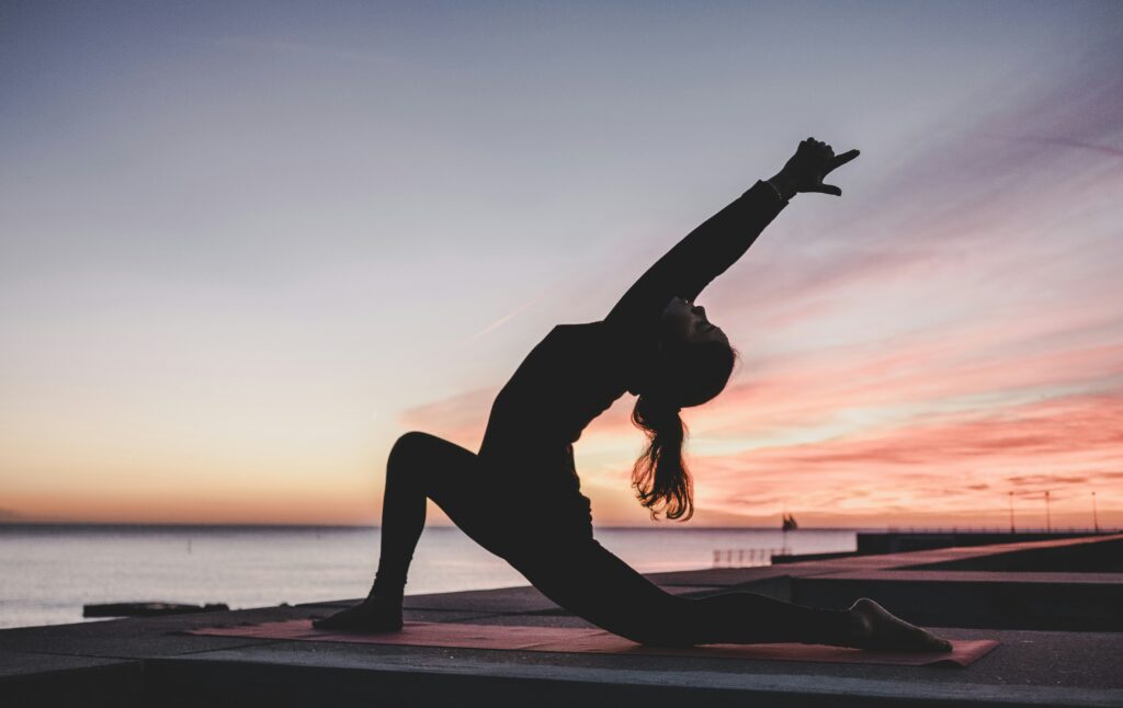 Femme en posture de yoga au lever du jour