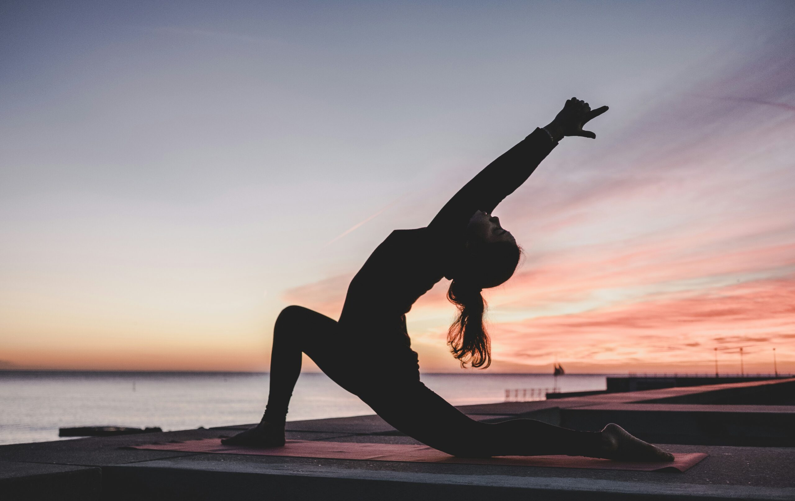Femme en posture de yoga au lever du jour